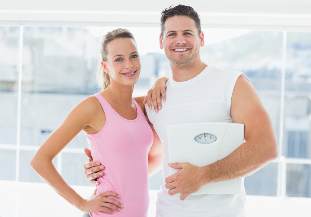photodune-12308328-portrait-of-a-fit-couple-holding-weighing-scale-in-bright-exercise-room-xxl.jpg